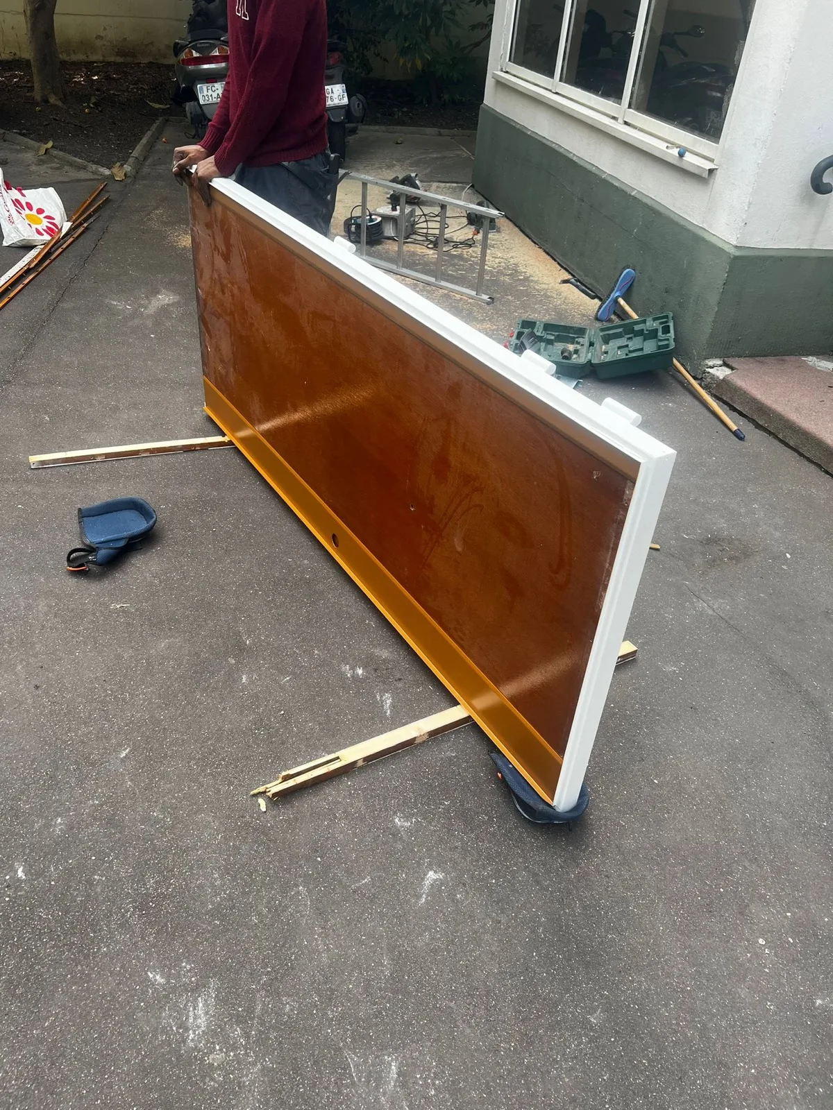 Vantail en bois verni posé à plat sur le sol pendant l'intervention, rue des Quatre Cheminées à Boulogne-Billancourt