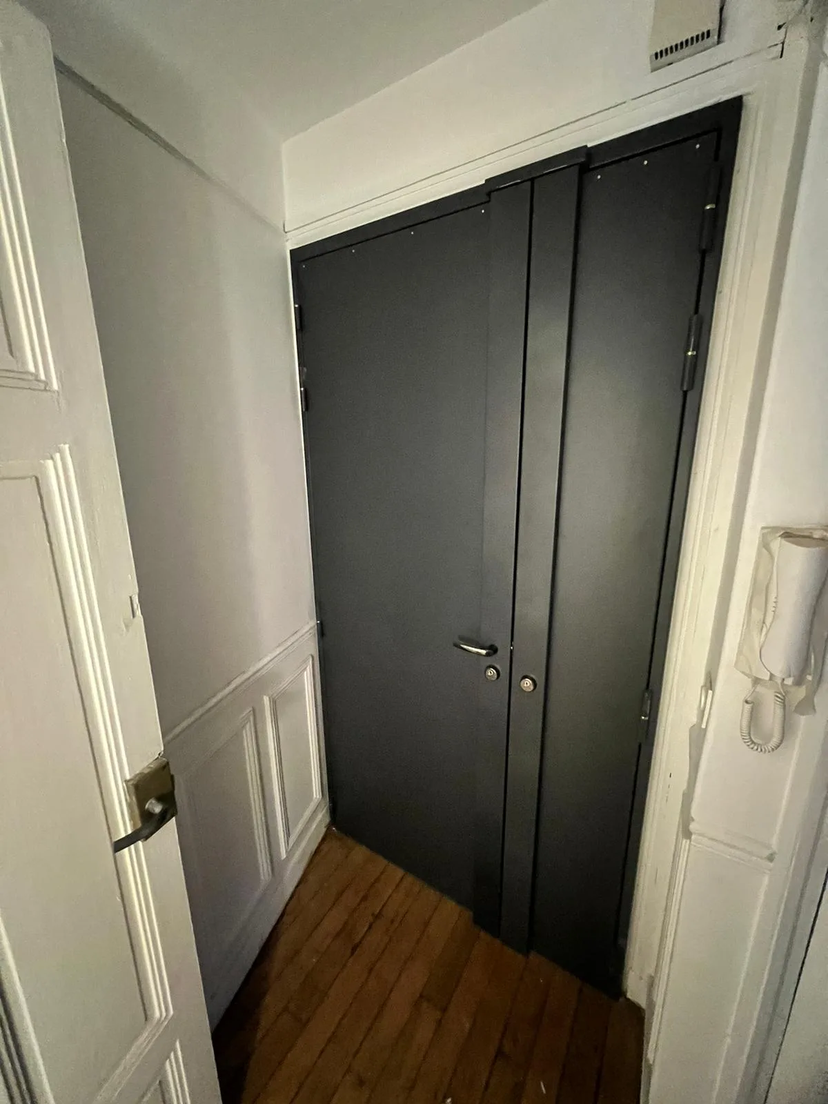 Porte palière à deux vantaux gris anthracite vue depuis un couloir en parquet, rue Jean Bouveri à Boulogne-Billancourt