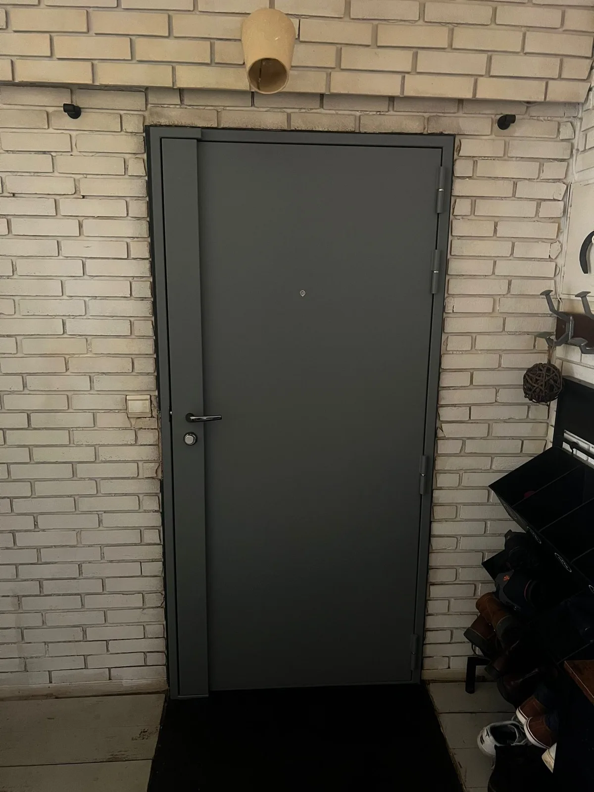 Porte anthracite fermée dans un local en briques blanches, passage Belle Feuille à Boulogne-Billancourt, après pose d'une serrure multipoints Héraclès